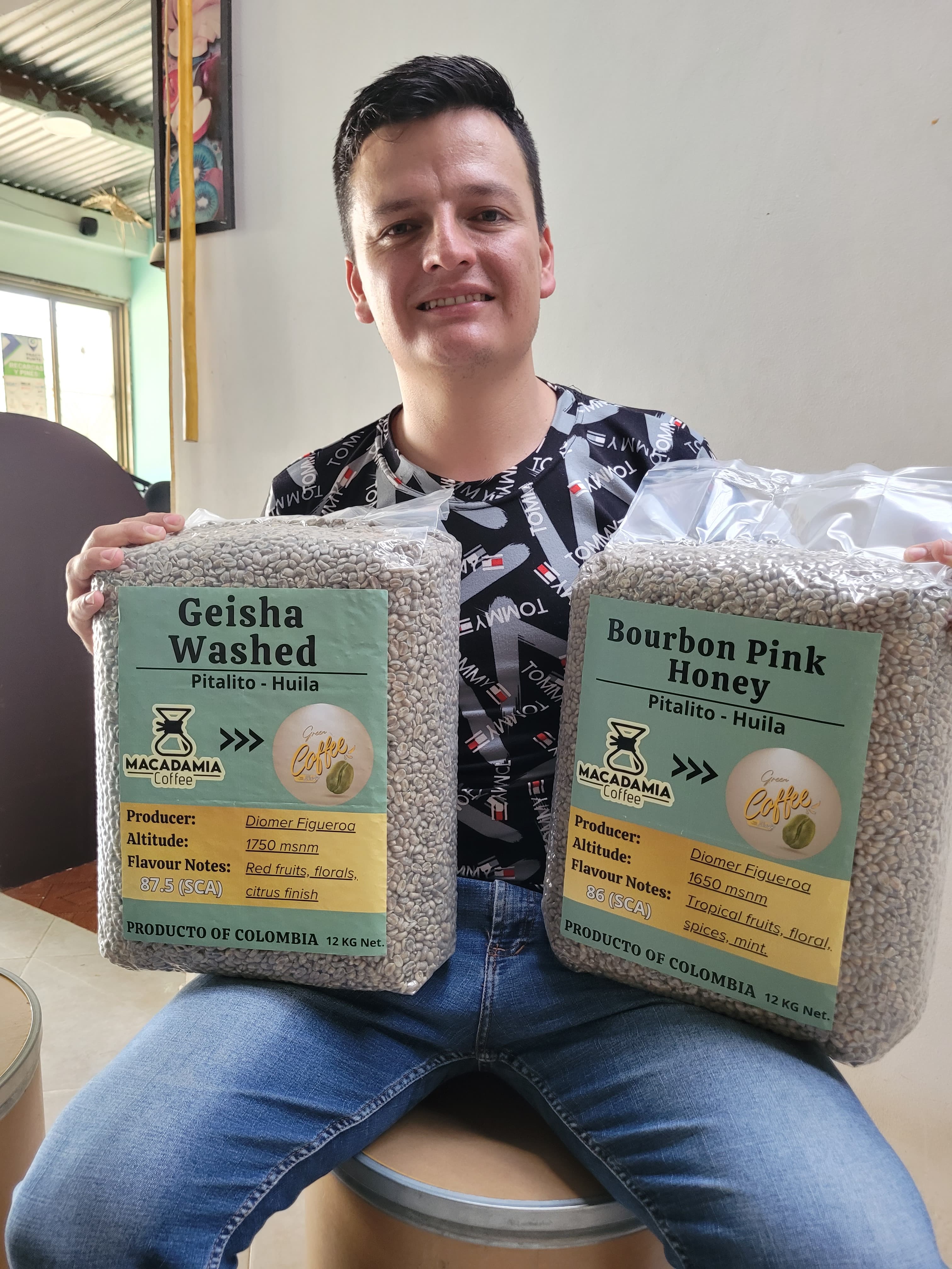 "Caficultor colombiano Diomer Figueroa sosteniendo microlotes de café verde de especialidad: Geisha Lavado y Bourbon Rosado Honey de Pitalito, Huila. Venta directa con trazabilidad a través de The Green Coffee Shop Colombia."